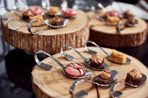 a group of wooden plates with desserts on them at Lindner Hotel Cologne City Plaza, part of JdV by Hyatt in Cologne