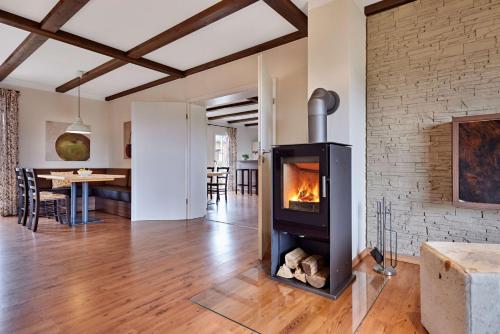 a living room with a fireplace and a dining room at Nürburgring Ferienpark in Nürburg