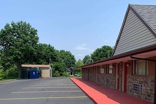 a red brick building with a red sidewalk in a parking lot at Super 8 by Wyndham Youngstown Girard in Youngstown