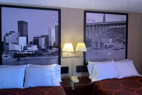 a hotel room with two beds and a picture of a city at Super 8 by Wyndham Youngstown Girard in Youngstown