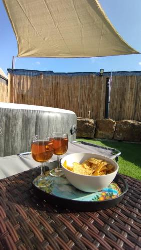 a table with a bowl of food and two glasses of wine at Casale Sammartano Apartments in Ummari