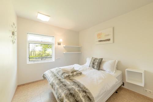 a bedroom with a bed with a dog laying on it at Beautiful family home in South-Iceland perfect for groups and families in Hella