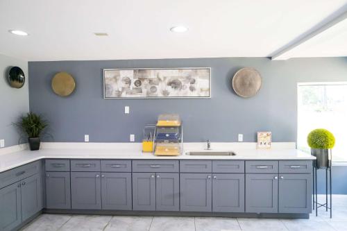 uma cozinha com armários azuis e um lavatório em Baymont by Wyndham College Park Atlanta Airport South em Atlanta