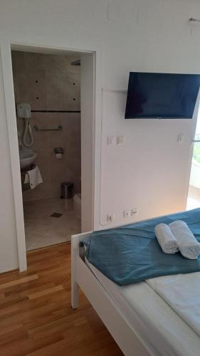 a bedroom with a bed and a bathroom with a shower at Pool apartment Adriana in Pag