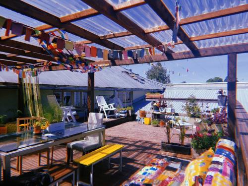 a patio with a wooden roof with a table and chairs at Looming Hostel in Tartu