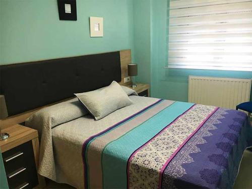 a bedroom with a large bed with blue walls at AP. FORCELLEDO in Posada de Llanes