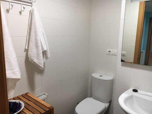 a white bathroom with a toilet and a sink at AP. FORCELLEDO in Posada de Llanes