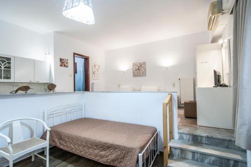 ein kleines Zimmer mit einem Bett und einer Küche in der Unterkunft Chrissomalli Sofia Studios in Skiathos-Stadt