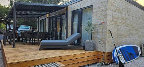 ein Haus mit einer Bank auf einer Holzterrasse in der Unterkunft MH Holiday Dream - Morning Sun in Drage