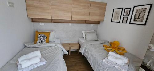 a small room with two beds and a cabinet at MH Holiday Dream - Morning Sun in Drage