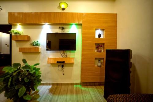a living room with a flat screen tv on a wall at Misty Mount Villa in Mahabaleshwar