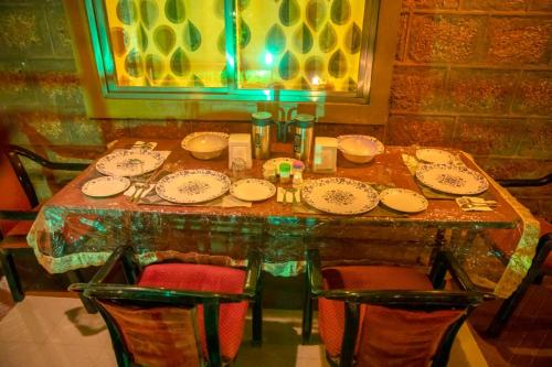 a dining room table with plates and chairs at Misty Mount Villa in Mahabaleshwar