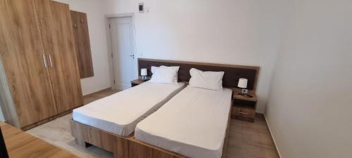 a bedroom with a large bed with white sheets at VILA DVG II in Costinesti