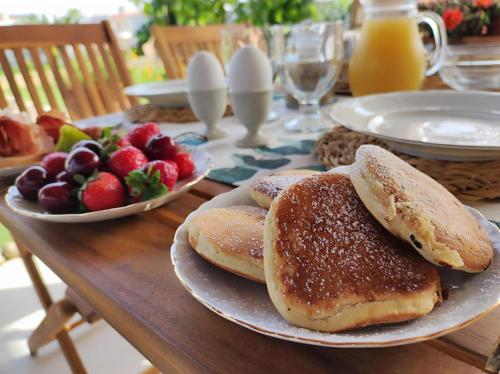 einen Tisch mit Pfannkuchen und einer Schale Obst in der Unterkunft Li Brilli in Felline