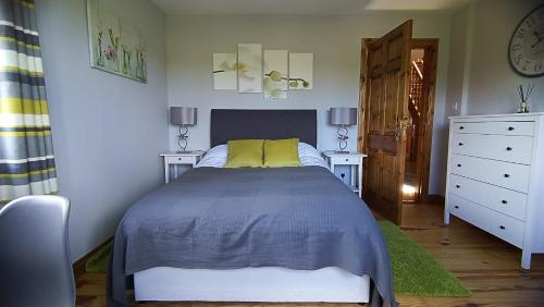 een slaapkamer met een bed en twee nachtkastjes bij Ard na Greine Bed & Breakfast Ballylickey in Ballylickey