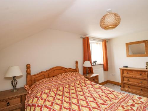 a bedroom with a bed and two lamps and a window at Mossy Lodge in Shrewsbury