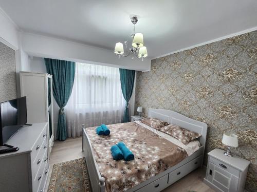 una camera da letto con un letto con due cuscini blu sopra di Luxe Hideaway Apartments a Iaşi