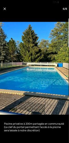 una piscina con acqua blu e alberi sullo sfondo di Calme,Tranquilité et Piscine pour se relaxer 
