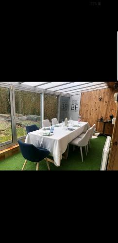 a dining room with a white table and chairs at Calme,Tranquilité et Piscine pour se relaxer 