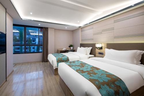 a hotel room with two beds and a window at Morninginn, Phoenix Ancient City Tuojiang in Fenghuang