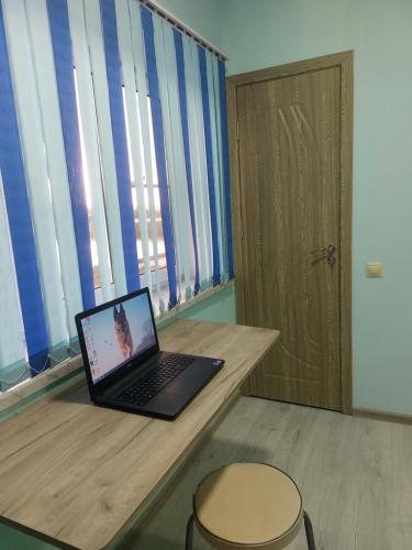 a laptop computer sitting on a wooden desk with a stool at Lake House Gyumri in Noraber