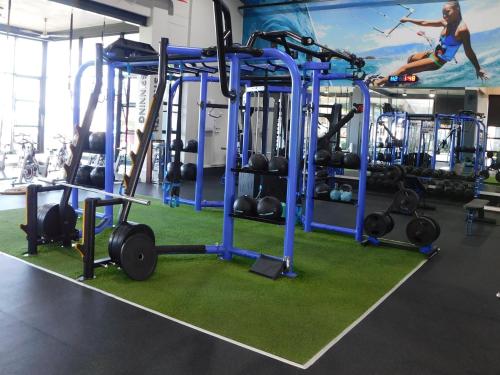 a gym with a woman in the middle of a squat rack with weights at Ballito Beach Vibes at Ballito Hills in Ballito