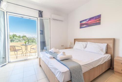 a bedroom with a bed and a balcony with a table at Urban Apt Next University 3 in Heraklio Town