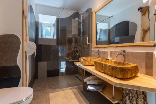 a bathroom with two wooden sinks and a toilet at Smileys Fluss Chalet in Trebesing
