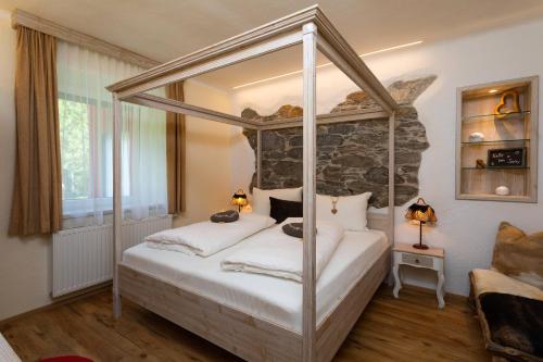 a bedroom with a four poster bed in a room at Smileys Fluss Chalet in Trebesing