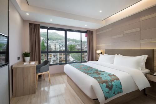 una camera d'albergo con un grande letto e una finestra di Morninginn, Phoenix Ancient City Tuojiang a Fenghuang