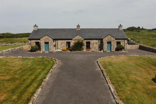 a large stone house with a driveway at Creevy Cottages in Rossnowlagh