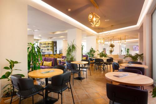 a restaurant with tables and chairs in a room at Alianthos Garden in Plakias