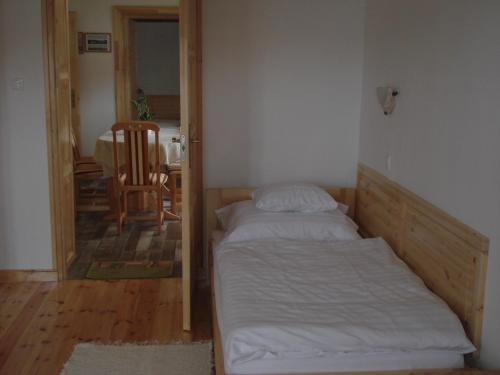 a small bedroom with a bed and a chair at Gerendás Vendégház in Sótony