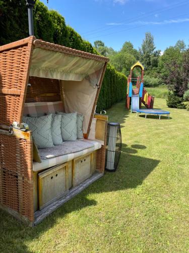 a wicker bench in a yard with a playground at Sarenka in Białka Tatrzanska