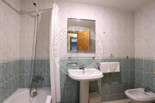 y baño con lavabo, bañera y espejo. en Apartamentos Paraíso Centro - BenidormParaíso, en Benidorm