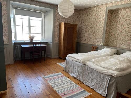 a bedroom with a bed and a desk and a window at Lägenhet i slott från 1600-talet in Uppsala