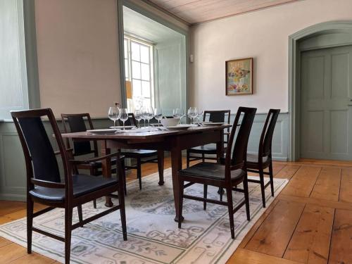 een eetkamer met een tafel en stoelen met wijnglazen bij Lägenhet i slott från 1600-talet in Uppsala