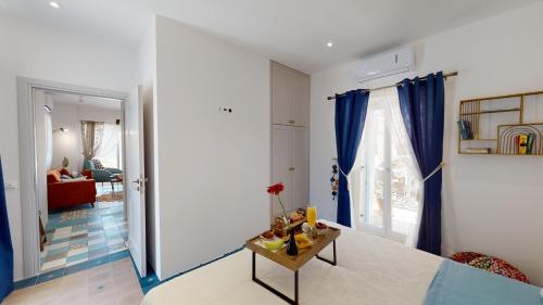 sala de estar con cortinas azules y mesa en Anassa Retro Kamilari, en Kamilari