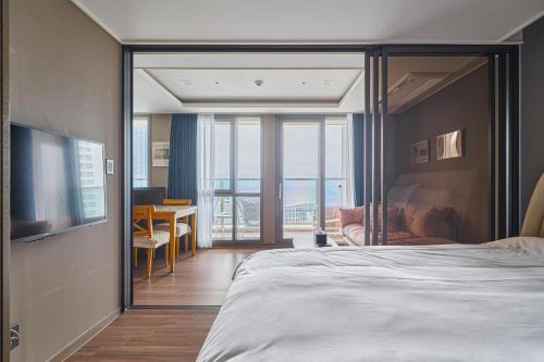 a bedroom with a large bed and a view of a room at Flat nearby Heaundae beach in Busan