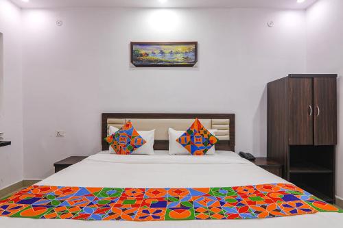 Un dormitorio con una cama con una manta de colores. en FabHotel A One Inn, en Lucknow