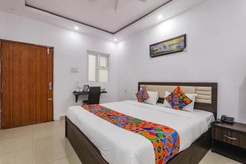 a bedroom with a large bed and a wooden door at FabHotel A One Inn in Lucknow
