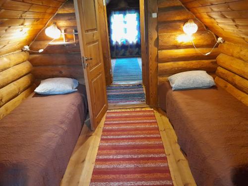 AinjaにあるKäbi Holiday Homesのログキャビン内の小さな部屋で、ベッド2台が備わります。