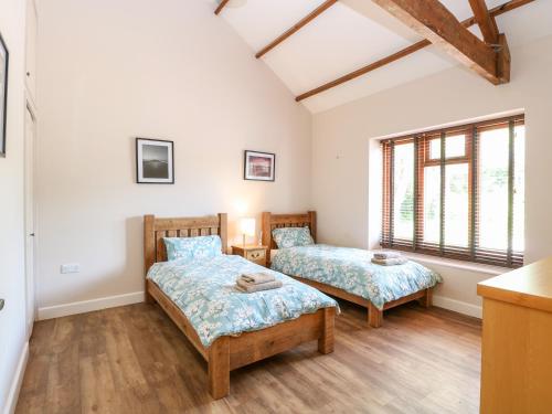 two beds in a room with two windows at The Barnhouse in North Walsham