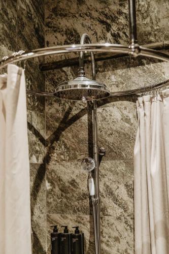a shower with a shower head and a shower curtain at Hotel Slottsvillan in Huskvarna