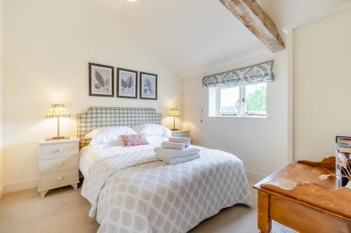 a bedroom with a bed and two lamps and a window at Giddy Cottage in Eastdean