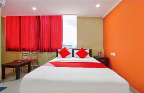 um quarto com uma cama grande e cortinas vermelhas em MANAN PARADISE em Bangalore