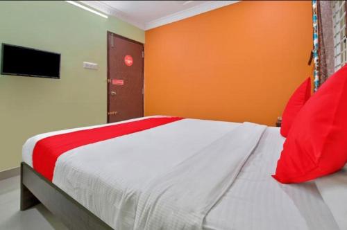 um quarto com uma cama grande e almofadas vermelhas em MANAN PARADISE em Bangalore