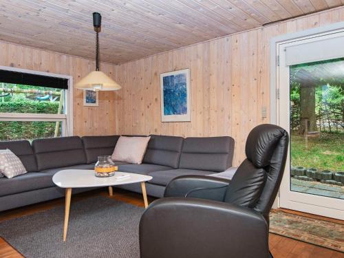 a living room with a couch and a table at 6 person holiday home in Alling bro in Nørager