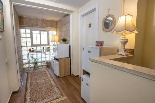 a kitchen with a refrigerator and a table with a lamp at Mike's House Jerusalem in Jerusalem