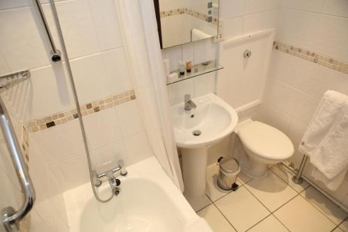 a white bathroom with a toilet and a sink at Kensington Court Hotel - Earls Court in London